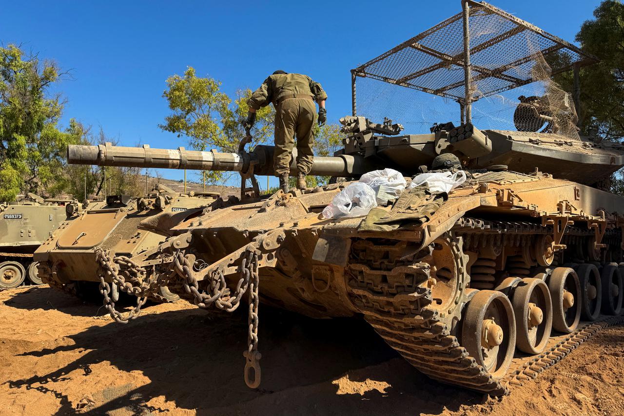 An Israeli soldier works on a tank on the Israeli side of the Israel-Lebanon border