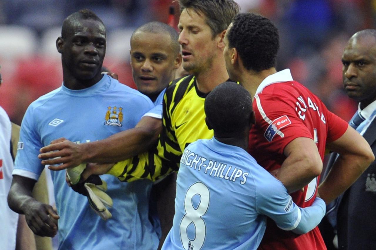 'Manchester United\'s Rio Ferdinand (R) remonstrates with Manchester City\'s Mario Balotelli (L) at the end of their FA Cup semi-final soccer match at Wembley Stadium in London, April 16, 2011.  Manch