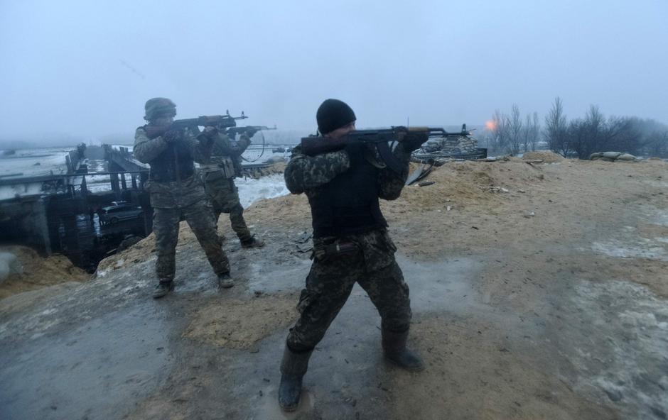 Ukrainian servicemen fire their weapons during fighting with pro-Russian separatists in Pesky village, near Donetsk January 21, 2015. Ukrainian President Petro Poroshenko accused Russia on Wednesday of sending 9,000 troops to back separatist rebels in the