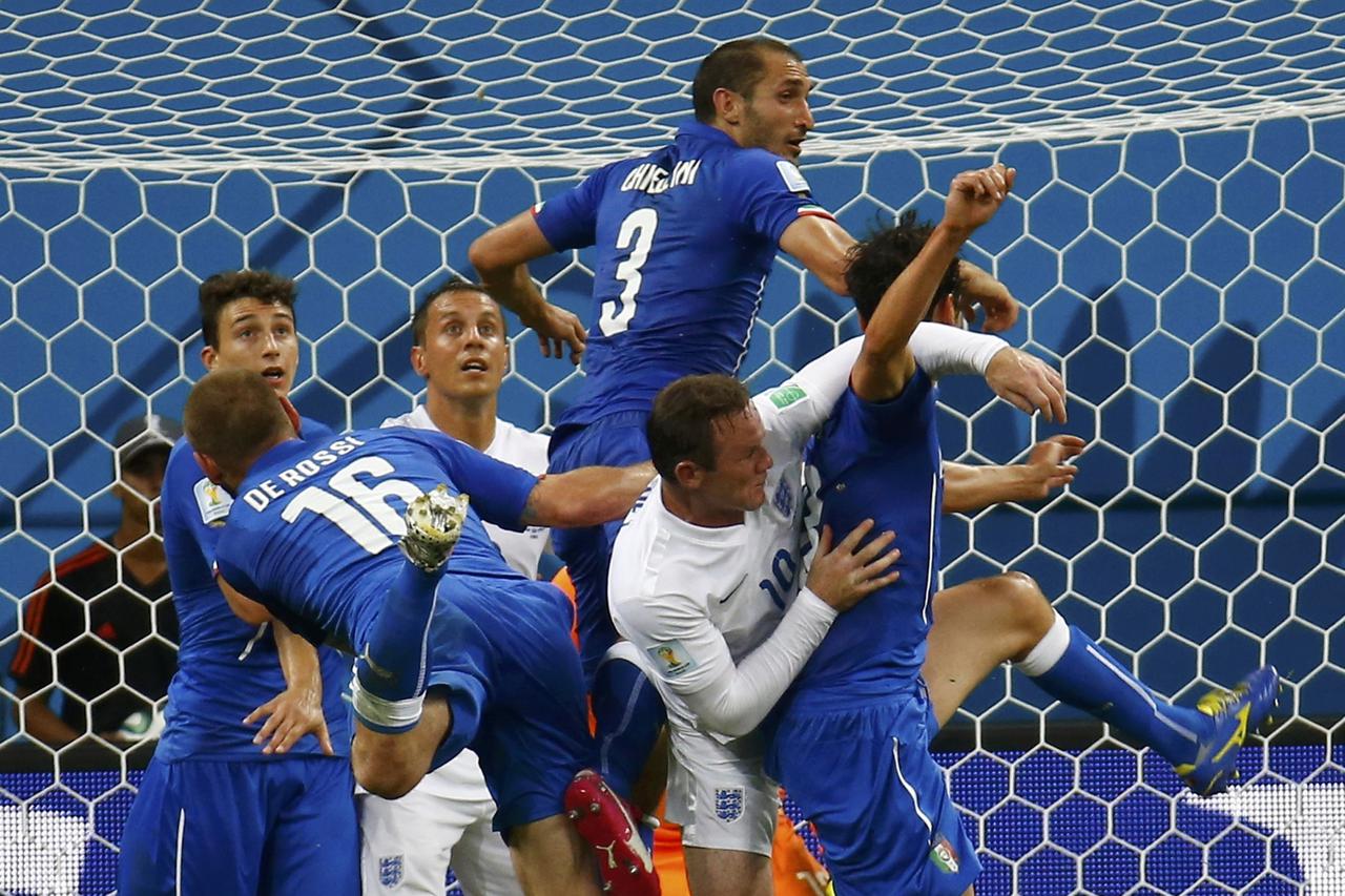 Italy's Daniele De Rossi (16), Giorgio Chiellini (3) and teammates jump for the ball against England's Wayne Rooney (10) and Phil Jagielka during their 2014 World Cup Group D soccer match at the Amazonia arena in Manaus June 14, 2014. REUTERS/Kai Pfaffenb