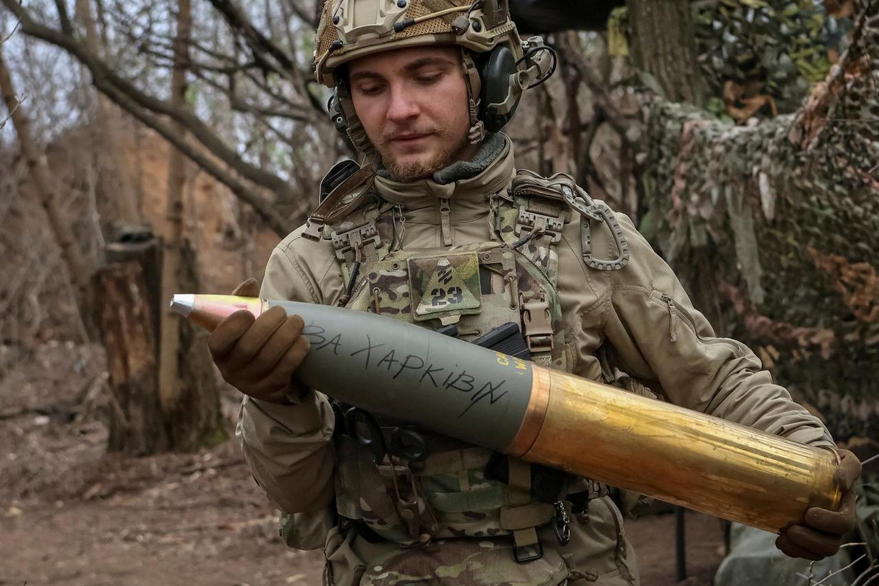 FILE PHOTO: A serviceman of the National Guard of Ukraine prepares a shell for a howitzer at a position in a front line in Donetsk region