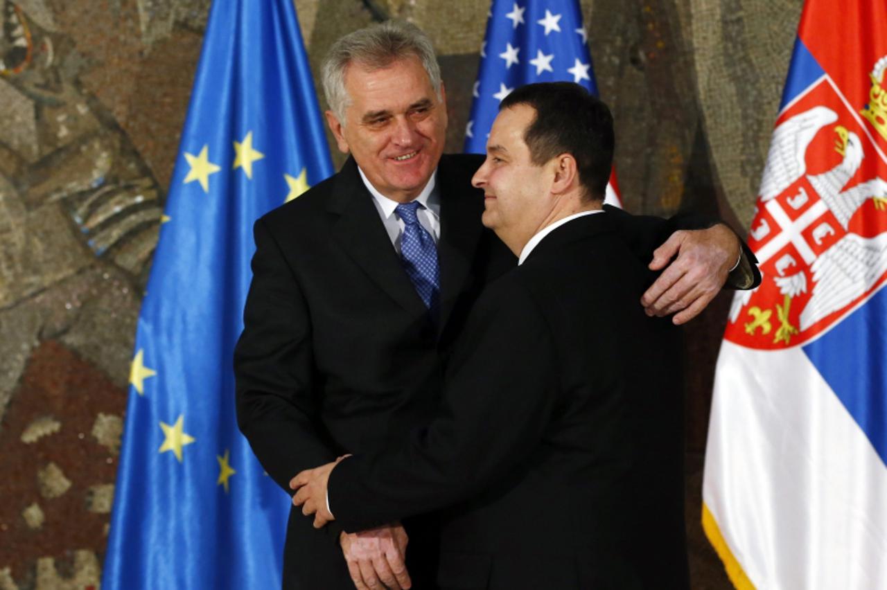 'Serbian President Tomislav Nikolic (L) hugs Serbian Prime Minister Ivica Dacic (R) prior to their meeting with U.S. Secretary of State Hillary Clinton and EU foreign policy chief Catherine Ashton in 