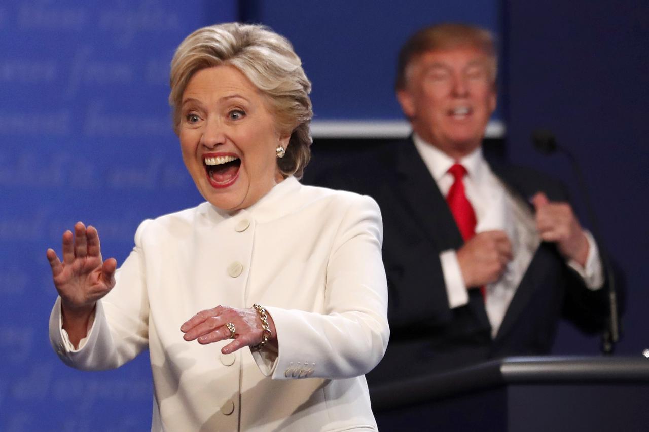 Democratic U.S. presidential nominee Hillary Clinton waves to a member of the audience as she walks off the debate stage as Republican U.S. presidential nominee Donald Trump remains at his podium after the conclusion of their third and final 2016 presiden