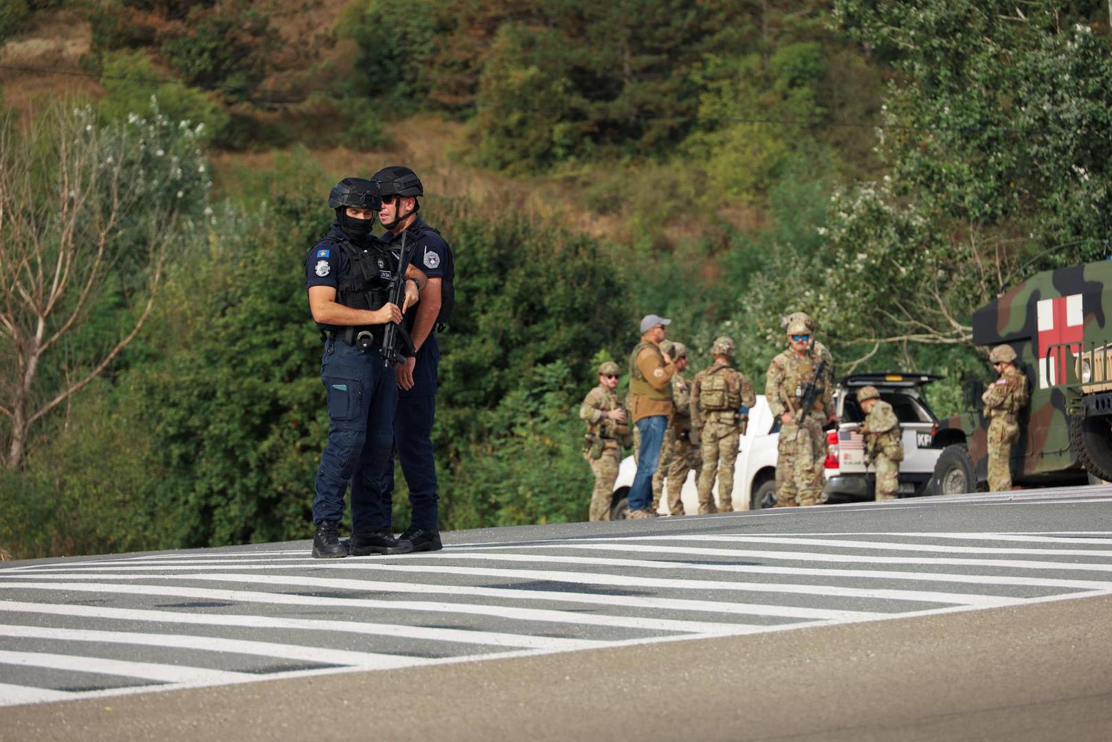 People work as Kosovo police and U.S. and EU troops stand by after one police officer was killed, another hurt in Kosovo gunfire, in Josevik, Kosovo September 24, 2023. REUTERS/Fatos Bytyci Photo: FATOS BYTYCI/REUTERS