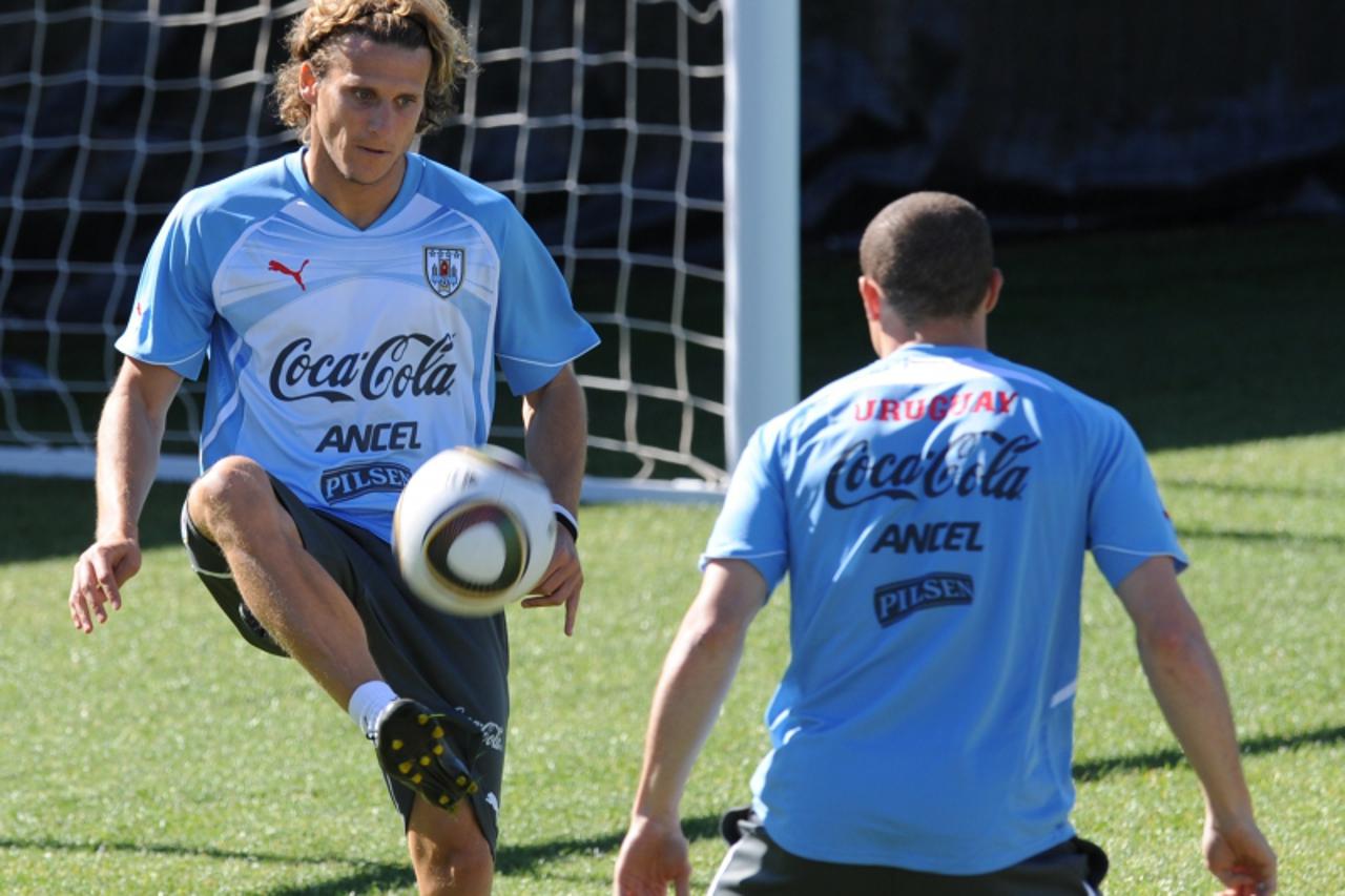 'Uruguay\'s striker Diego Forlan (L) controls the ball during a team training session on June 8, 2010 ahead of the start of the 2010 World Cup football tournament in South Africa.  AFP PHOTO / Rodrigo