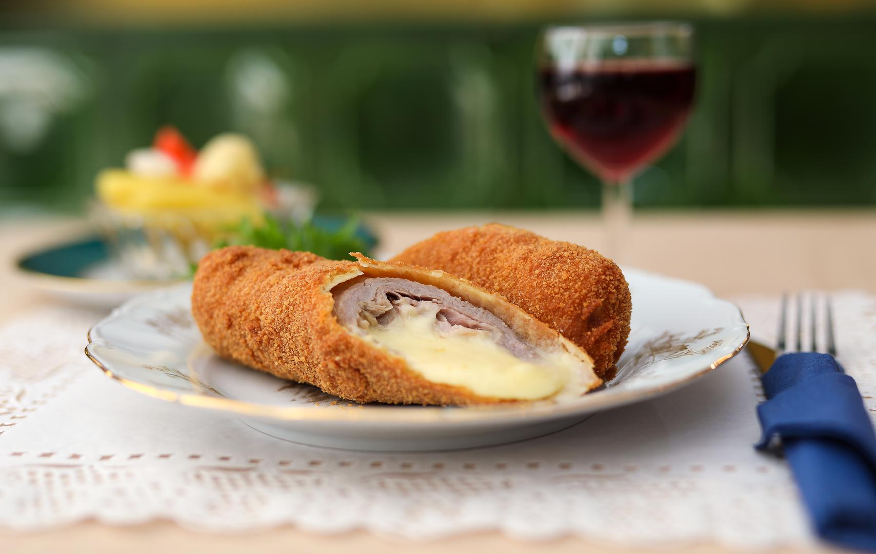 17. Zagrebački odrezak: Zagrebački odrezak tanki je teleći kotlet punjen šunkom i sirom, pohan i pržen. Nastao je u Zagrebu kao varijacija na francusko jelo Cordon Bleu i švicarski šnitel. Zagrebački odrezak najbolje je poslužiti svježe pečen kada je korica još hrskava, a sir mekan. Obično se poslužuje s rižom ili prženim krumpirićima. 