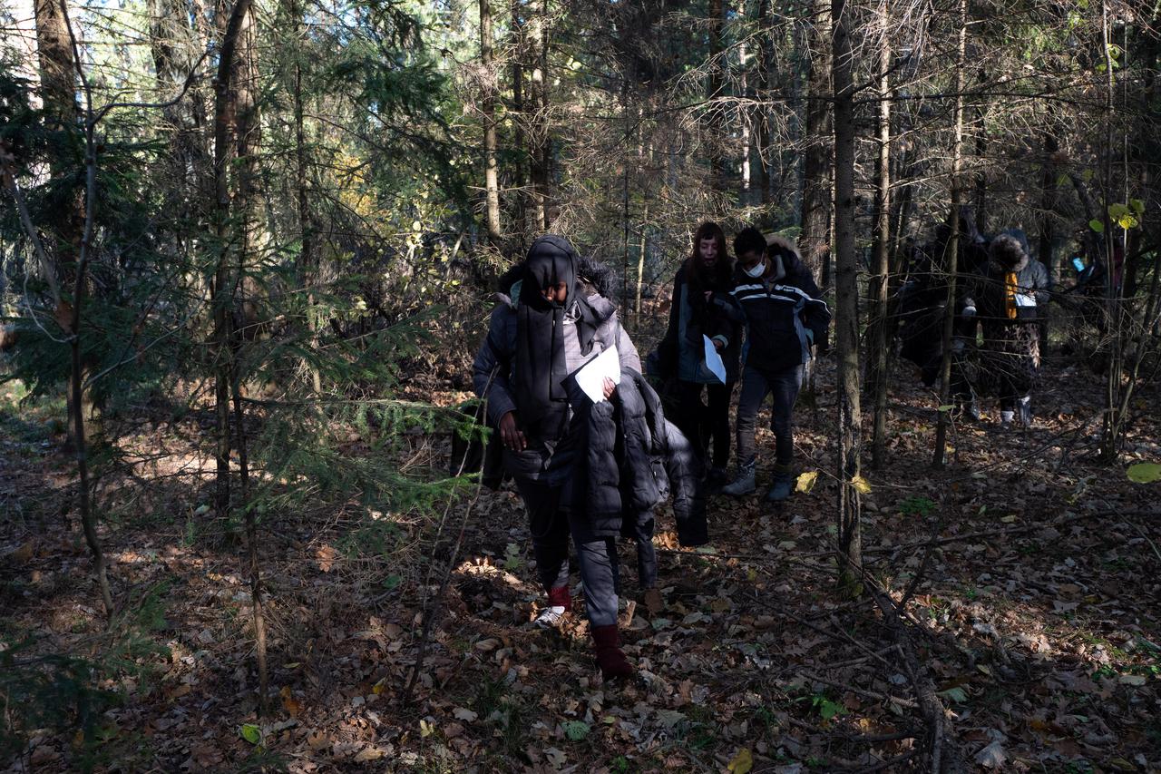 Migrants from Somalia walk through the forest as they cross the Belarusian-Polish border in Siemianowka