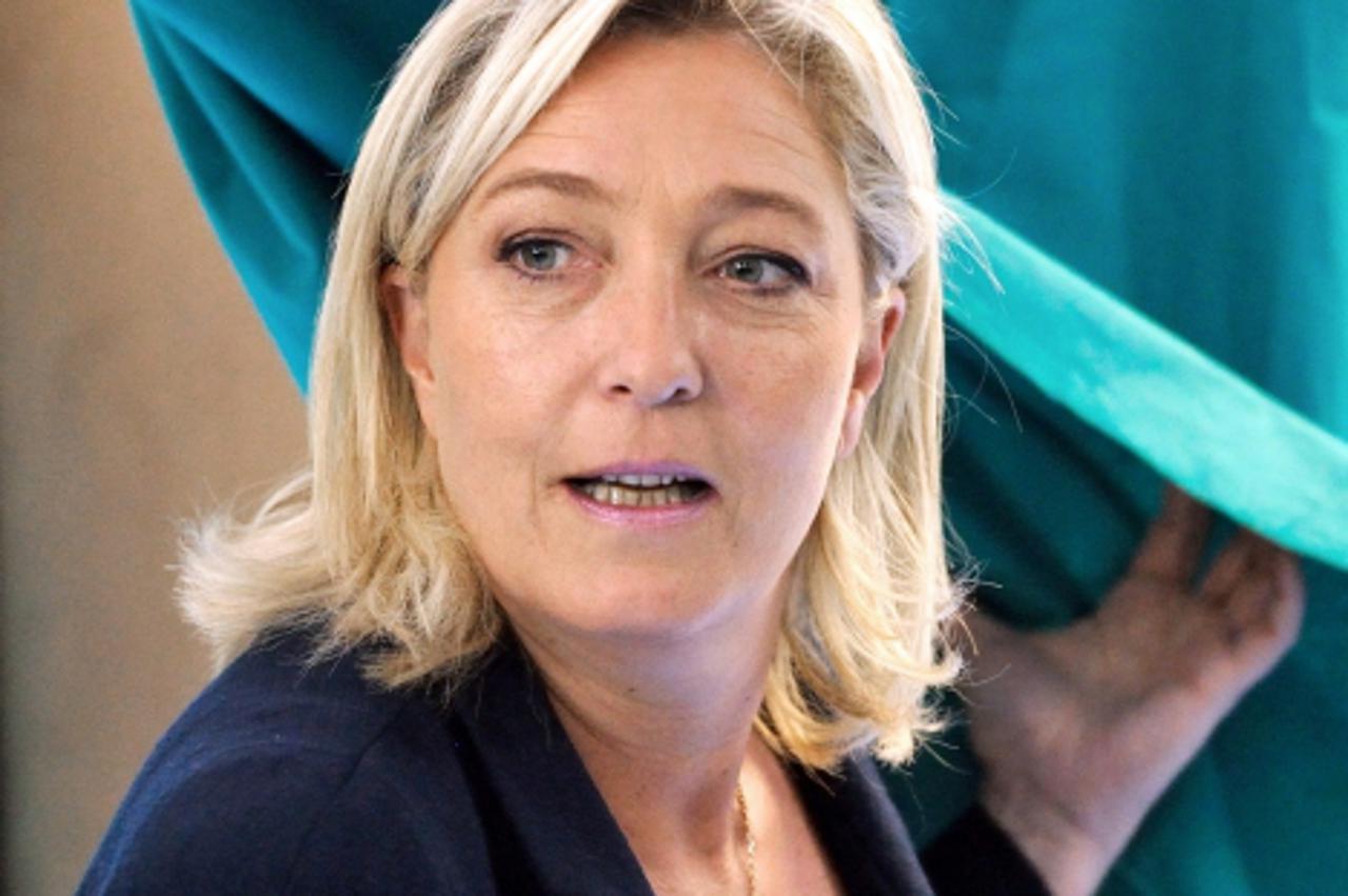 'Marine Le Pen, President of French far-right party Front national (FN) and candidate for the French parliamentary elections in the 11th constituency of Pas-de-Calais department, leaves the polling bo