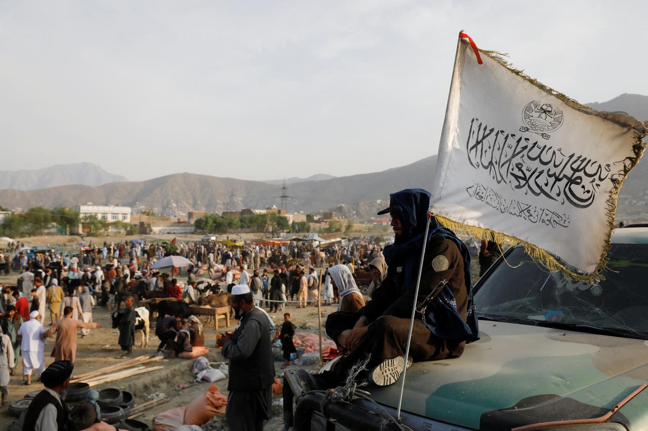 A Taliban fighter stands guard at a livestock market ahead of Eid al-Adha in Kabul