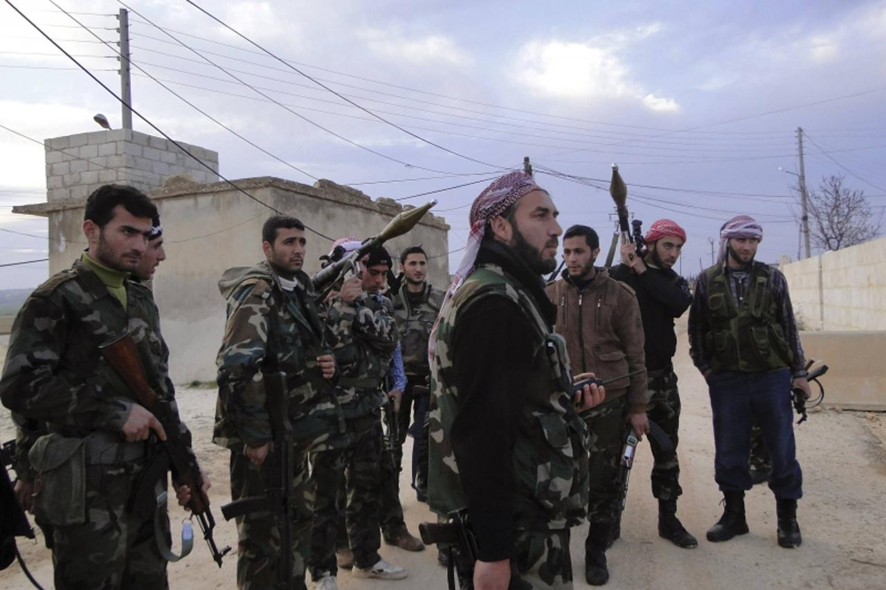 'Members of the Free Syrian Army stand with their weapons in the town of Nebel in Aleppo's countryside February 5, 2013. Picture taken February 5, 2013.    REUTERS/Mahmoud Hassano (SYRIA - Tags: CONF