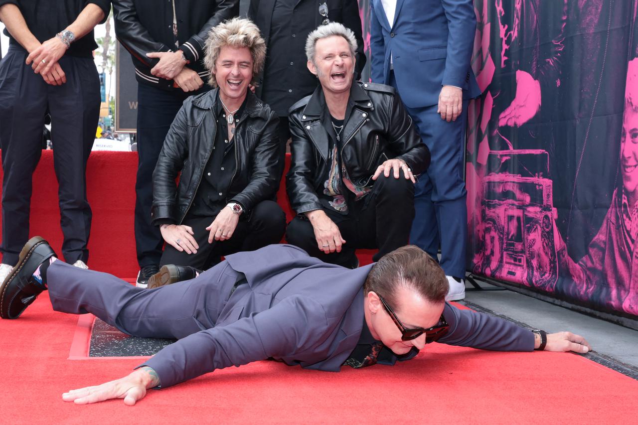 Billie Joe Armstrong, Mike Dirnt and Tre Cool from rock band Green Day pose on the day they unveil their star on the Hollywood Walk of Fame in Los Angeles