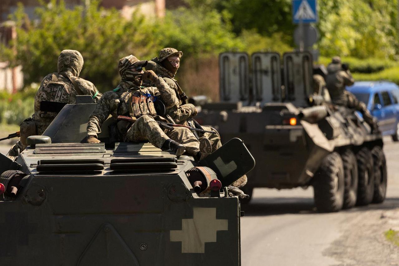 Ukrainian soldiers ride on an armored vehicle enroute to the front line, amid Russia's invasion in Ukraine, in Bakhmut in the Donetsk region