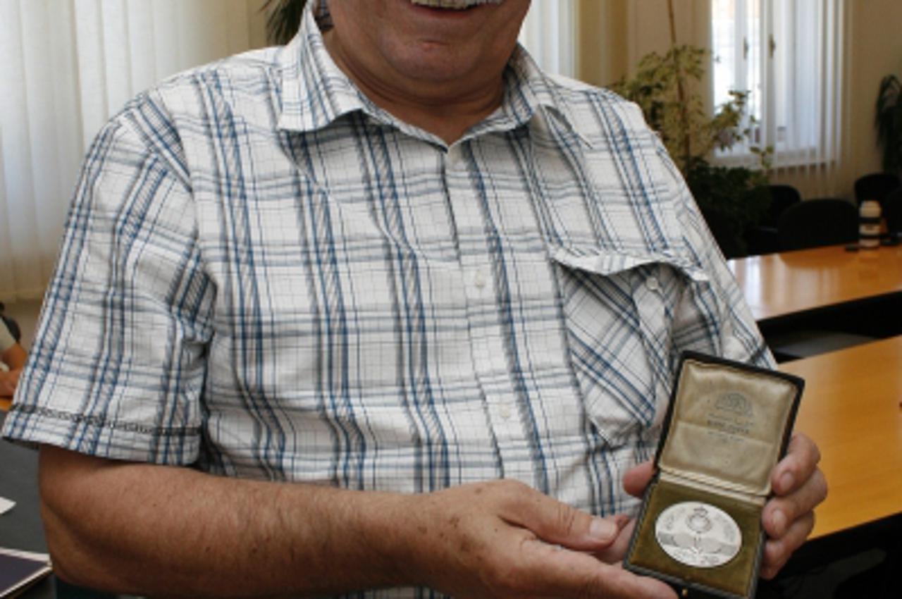 '25.06.2010., Koprivnica -  Branko Plese u rukama drzi prvu hrvatsku medalju s medjunarodnih sportskih natjecanja, koju je osvojio Zarko Dolinar. Photo: Marijan Susenj/PIXSELL'