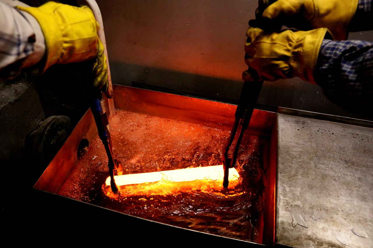 FILE PHOTO: Employees place an ingot of 99.98 percent pure palladium into water at a plant of Krastsvetmet in Krasnoyarsk