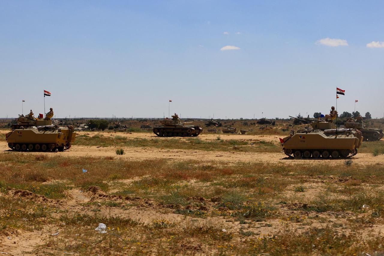 Military vehicles stand near the Rafah border crossing between Egypt and the Gaza Strip, in Rafah