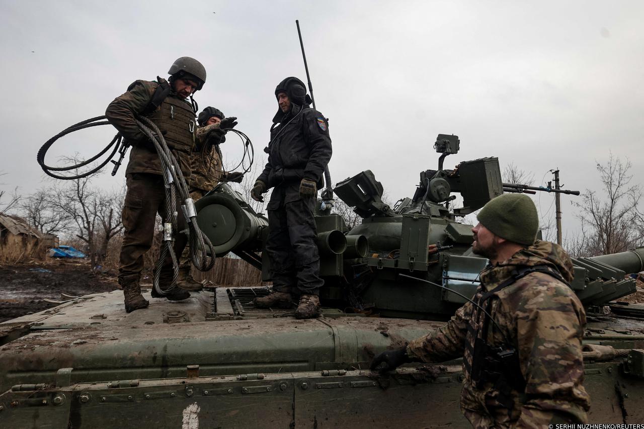 Ukrainian servicemen stand atop of a tank in a village near the frontline town of Kreminna