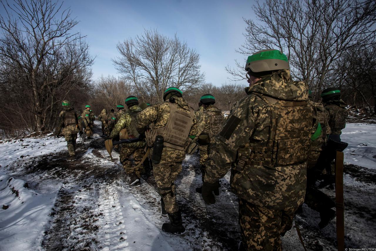 Ukrainian servicemen walk on a road outside the frontline town of Bakhmut