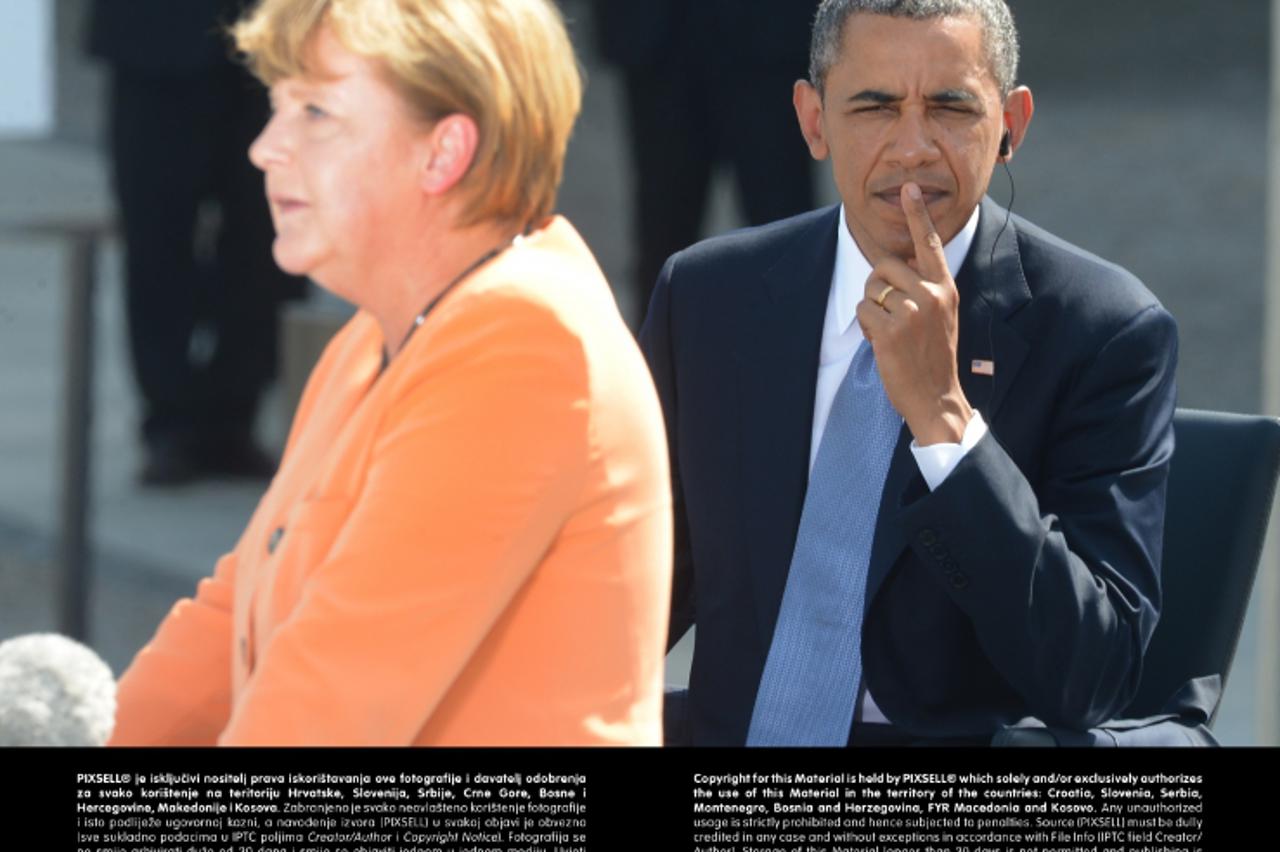 'US President Barack Obama (R) looks at German Chancellor Angela Merkel on a podium in front of the Brandenburg Gate at Pariser Platz in Berlin, Germany, 19 June 2013. Photo: Marcus Brandt/dpa +++(c) 