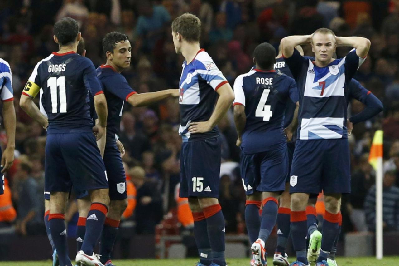 'Dejected Britain players console each other after losing to South Korean on penalty kicks in their men\'s quarter final soccer match at the London 2012 Olympic Games at Millennium Stadium in Cardiff 