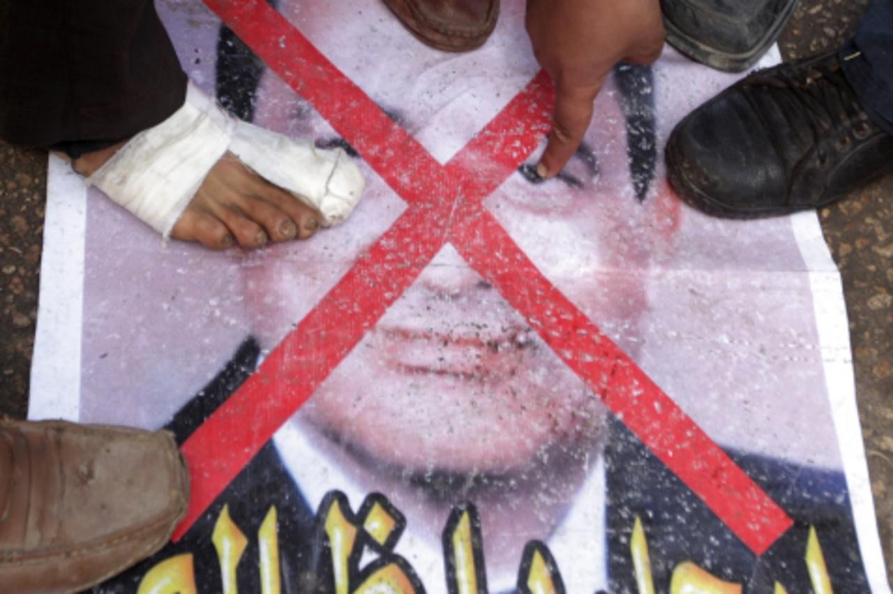 'Egyptian anti-government protesters step on a picture of President Hosni Mubarak in Cairo\'s Tahrir Square on February 06, 2011, on the 13th day calling for the ouster of President Hosni Mubarak\'s r
