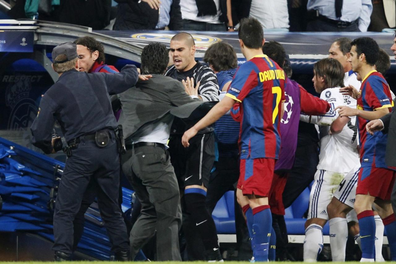\'Real Madrid\'s delegate and former player Chendo (2nd L) fights with Barcelona\'s goalkeeper Victor Valdes (3rd L) during their Champions League semi-final first leg soccer match at Santiago Bernabe