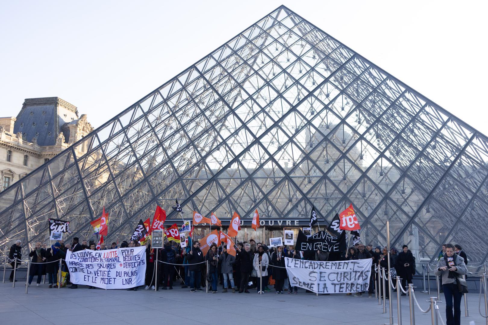 Museum staff hold banners outside the Pyramid of the Louvre Museum as workers voted to go on strike against increasingly deteriorating working conditions and the declining visitor experience at the world famous museum, in Paris on December 15, 2025. Photo by Raphael Lafargue/ABACAPRESS.COM Photo: Lafargue Raphael/ABACA/ABACA