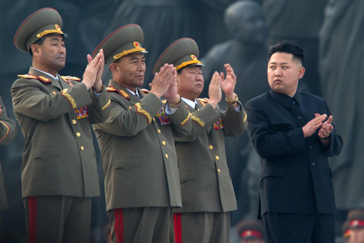 '(FILES) This file photo taken on April 13, 2012 shows North Korean leader Kim Jong-Un (R) clapping as he attends the unveiling ceremony of two statues of former leaders Kim Il-Sung and Kim Jong-Il in
