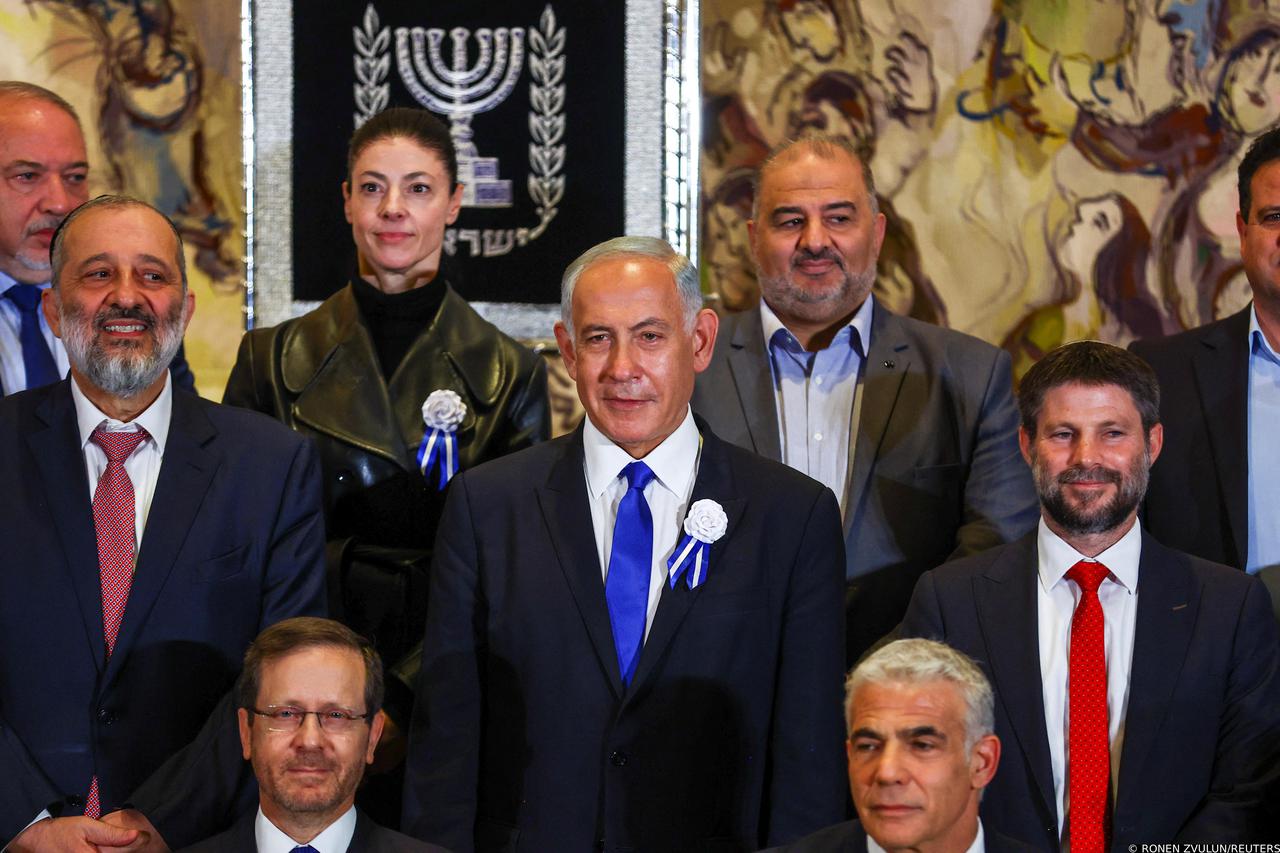 Prime Minister-designate Benjamin Netanyahu stands among members of the new Israeli parliament after their swearing-in ceremony in Jerusalem