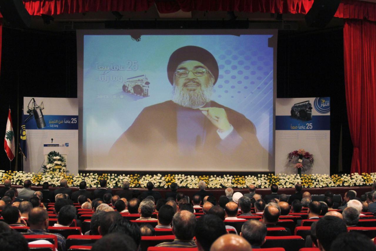 'Lebanon\'s Hezbollah leader Sayyed Hassan Nasrallah is projected on a screen during a live broadcast as he speaks to his supporters at an event marking the 25th anniversary of the establishment of Al