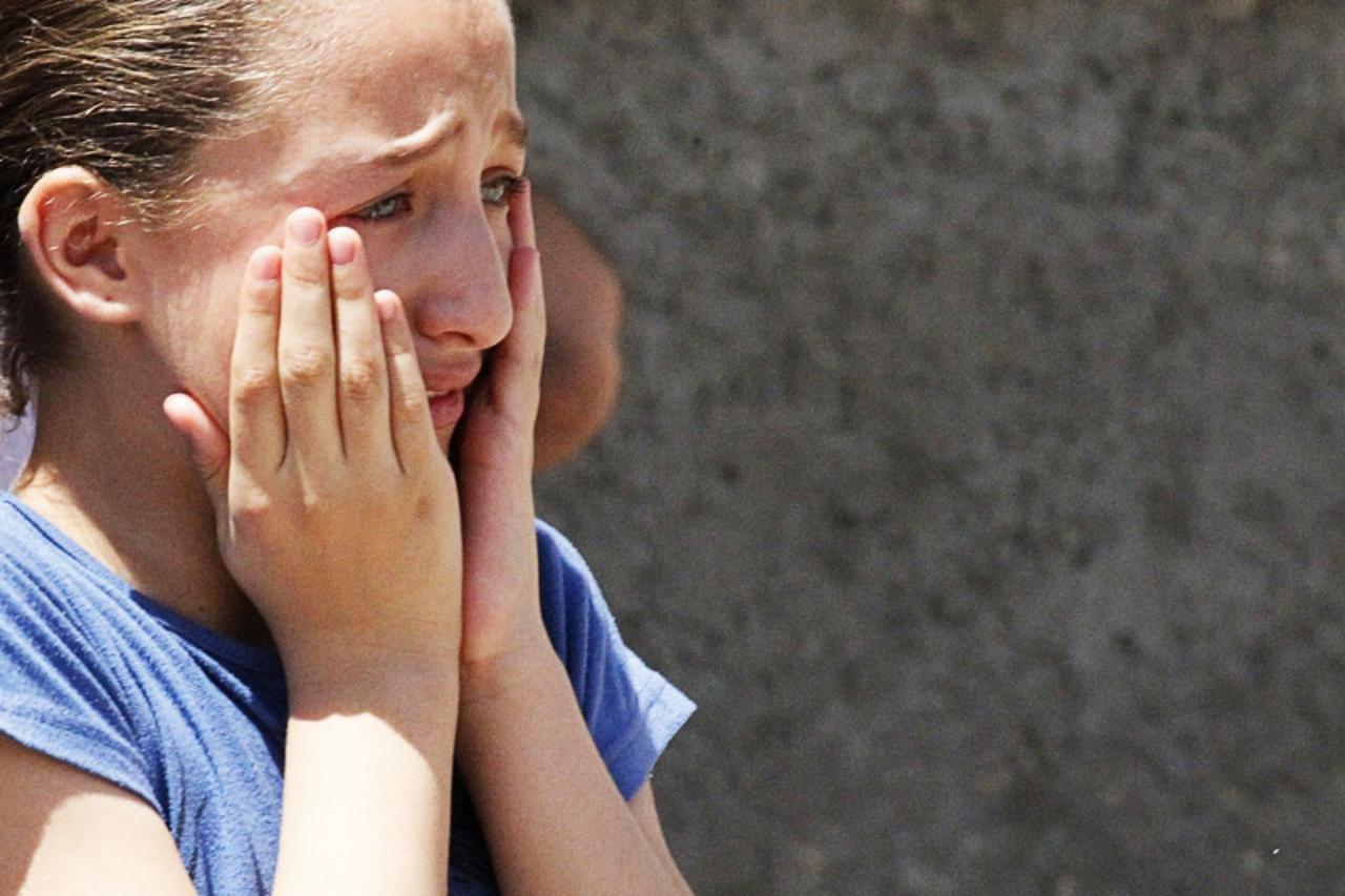 'A girl cries upon seeing the damage after what activists said was an air raid by forces loyal to Syria's President Bashar al-Assad in Raqqa province, eastern Syria, August 10, 2013. REUTERS/Nour Fou