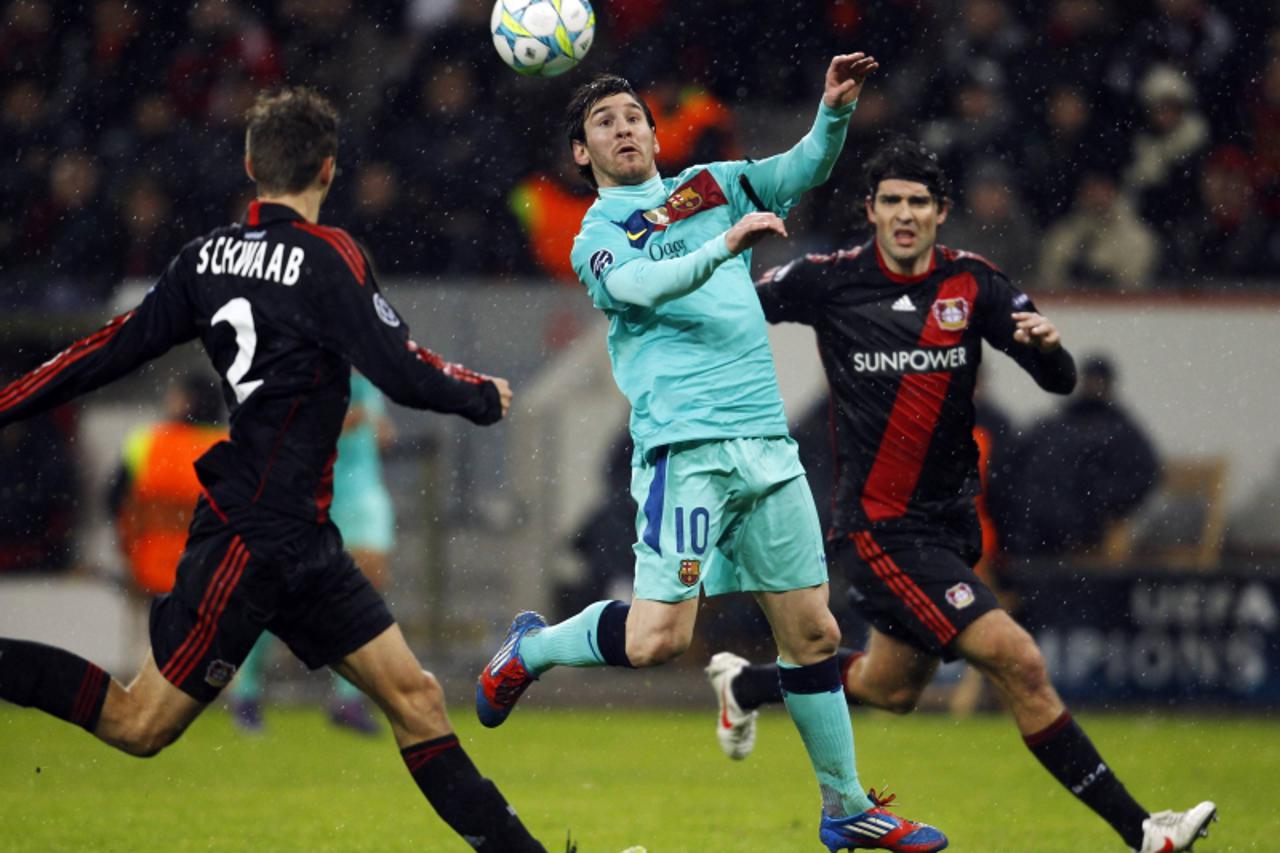 \'Bayer Leverkusen\'s Daniel Schwaab (L) and Vedran Corluka challenge FC Barcelona\'s Lionel Messi (C) during their Champions League soccer match in Leverkusen February 14, 2012. REUTERS/Ina Fassbende