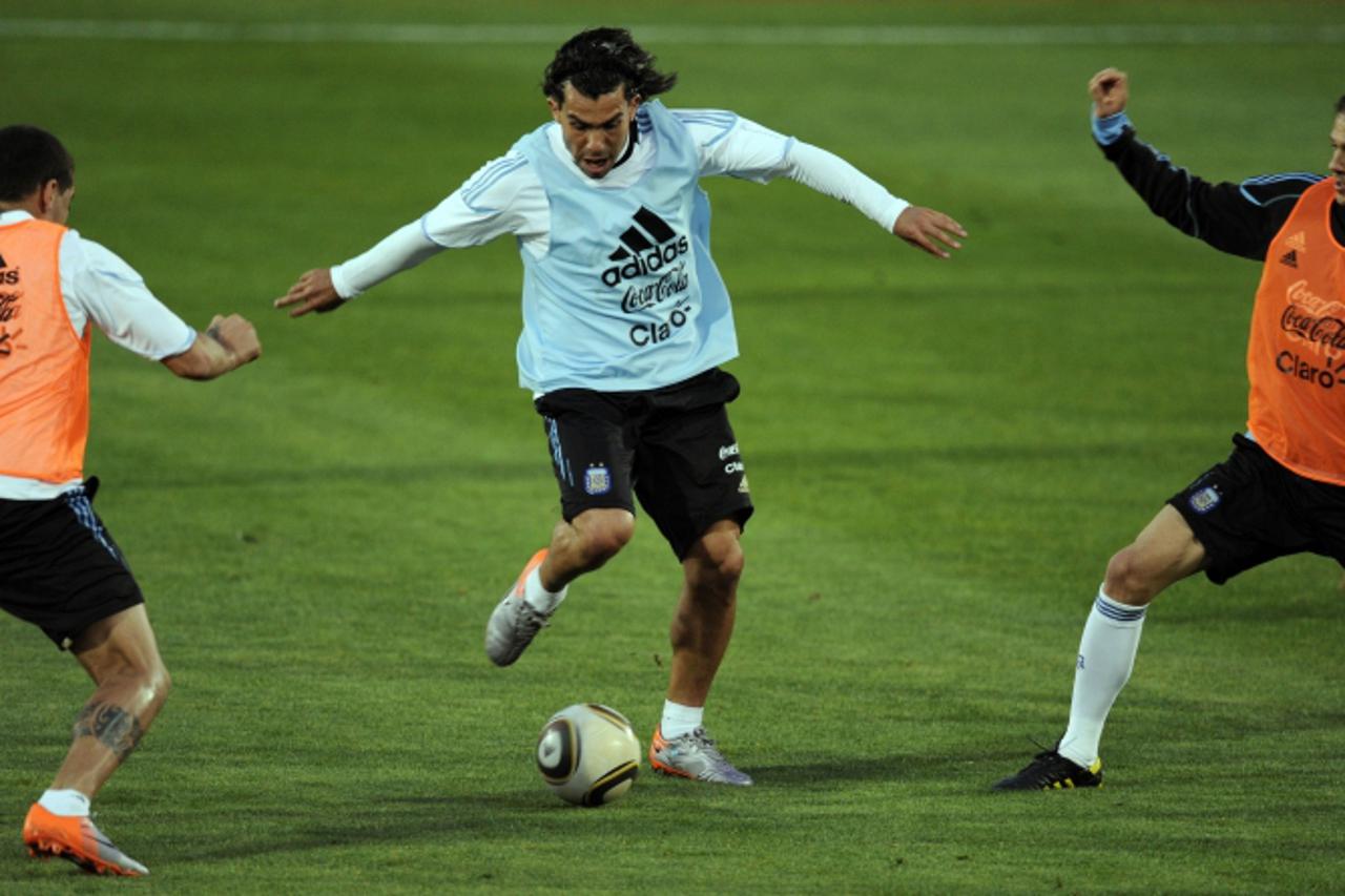 'Argentine forward Carlos Tevez drives the ball between defenders Nicolas Ottamendi and Martin Demichelis during a training session at High Performance Center of Pretoria University on June 3, 2010.  