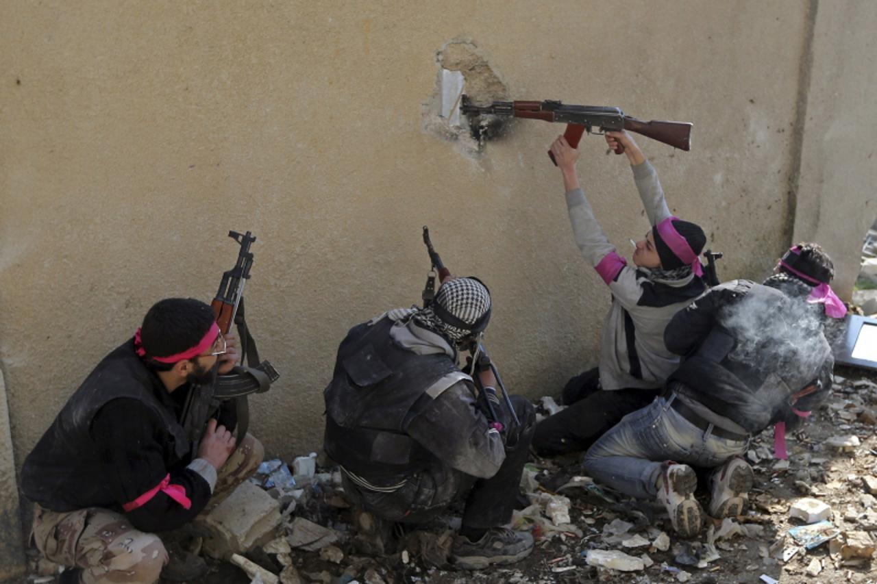 'A Free Syrian Army fighter fires a rifle through a hole in a wall of a Syrian Army base, just before he was shot in the head by a sniper, during heavy fighting in the Arabeen neighbourhood of Damascu