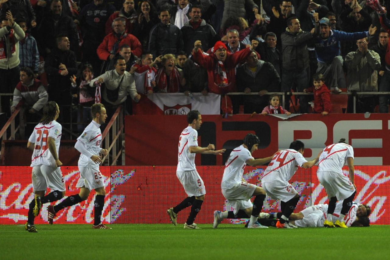 'Sevilla\'s players celebrate after scoring during their Liga football match Sevilla vs FC Barcelona at Ramon Sanchez Pizjuan stadium on March 13, 2011, in Sevilla.    AFP PHOTO/ JORGE GUERRERO '