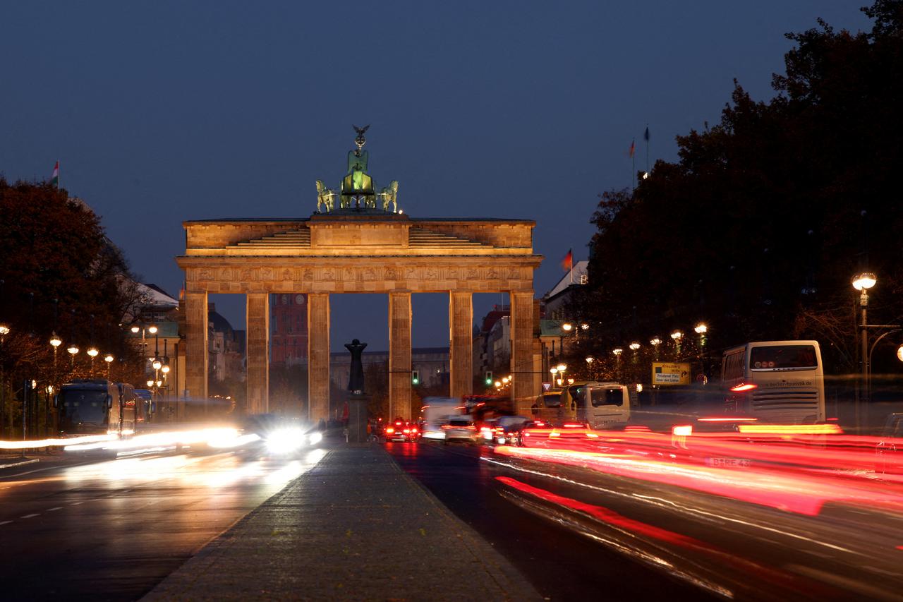 FILE PHOTO: Car traffic makes its way on a road in front of Brandenburg Gate in Berlin