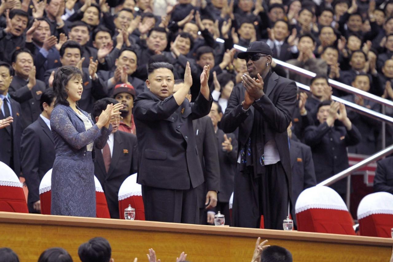 'North Korean leader Kim Jong-Un (C), his wife Ri Sol-Ju (L) and former NBA basketball player Dennis Rodman clap during an exhibition basketball game in Pyongyang in this undated picture released by N