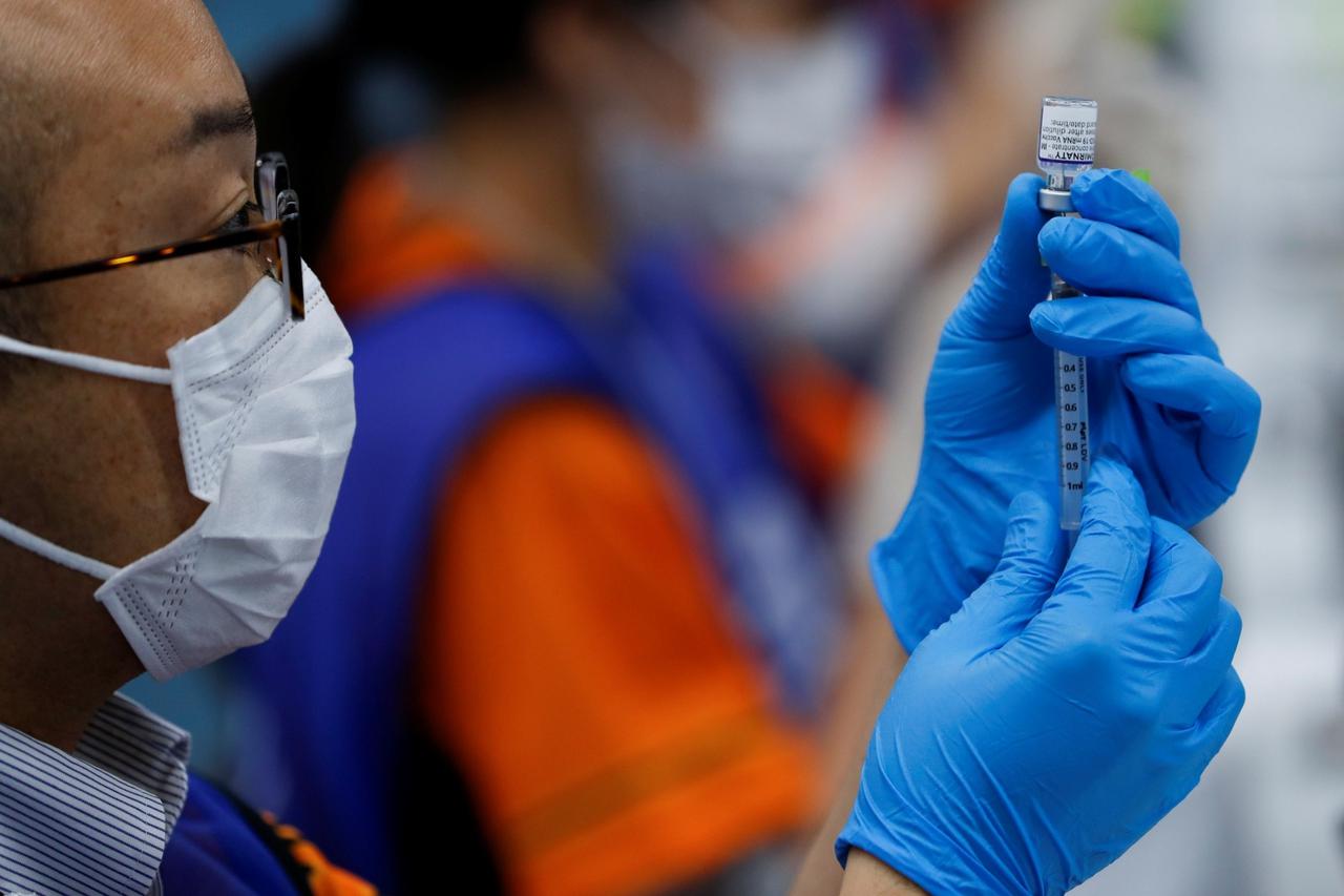 A health worker fills a syringe with a dose of the Pfizer-BioNTech coronavirus disease (COVID-19) vaccine at the Tokyo Dome in Tokyo