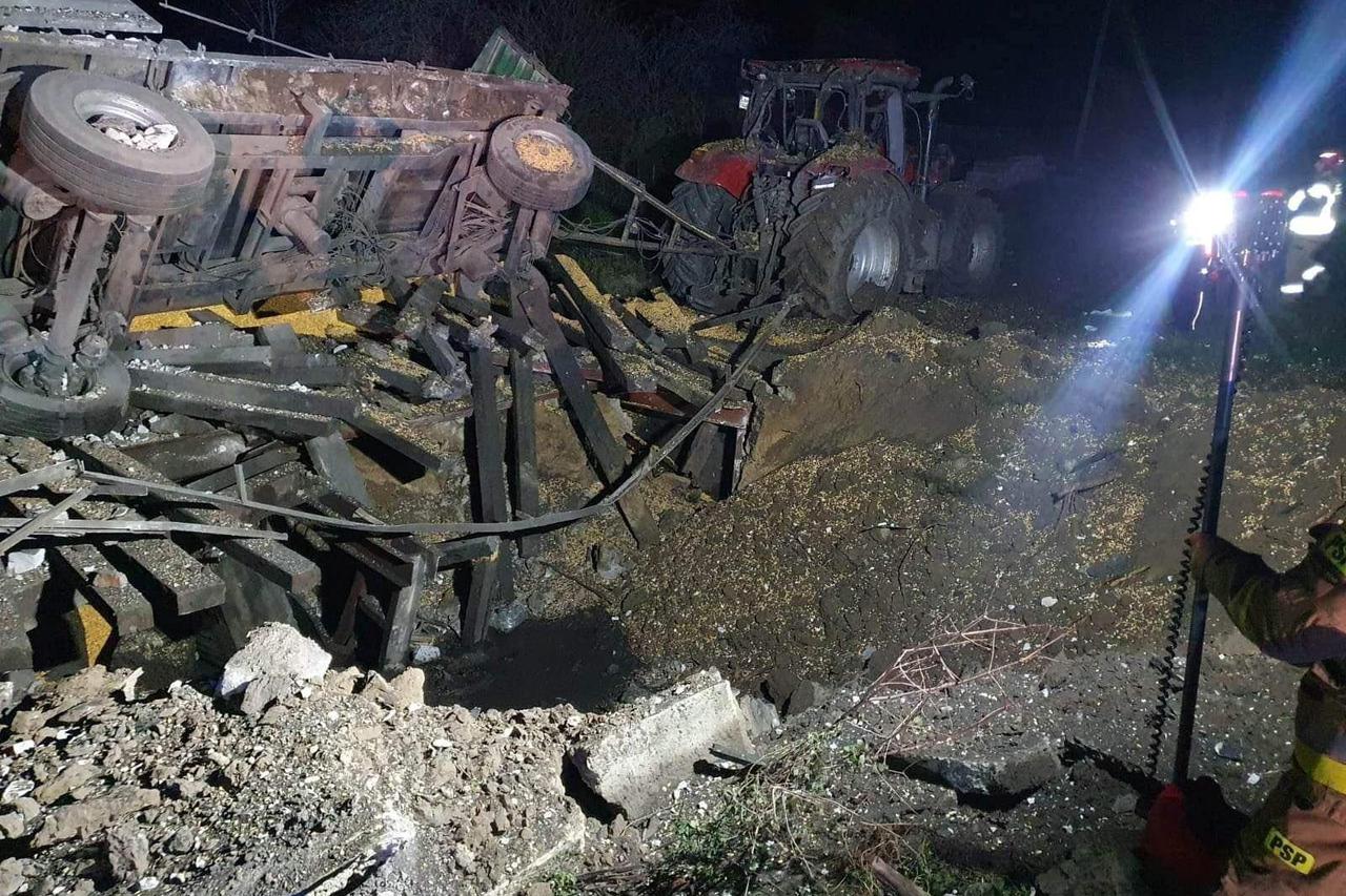 A damaged vehicle lies next to a crater formed at the site of an explosion in Przewodow