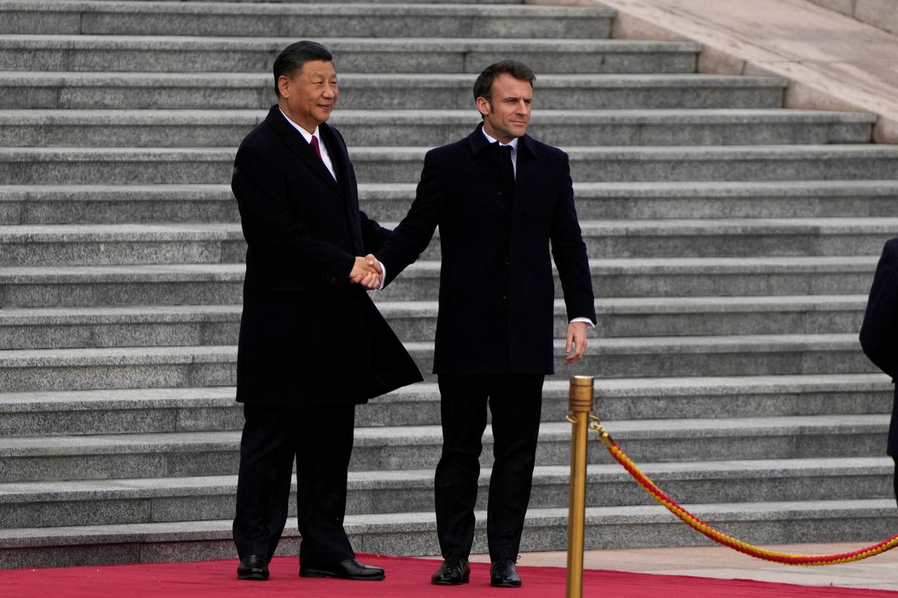 French President Emmanuel Macron shakes hands with Chinese President Xi Jinping