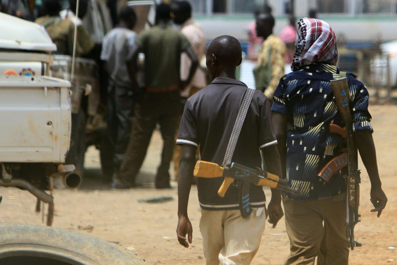'Armed men walk past on April 17, 2011 as resentment towards the capital Khartoum runs high in the restive town of Abyei, on the Sudanese north-south border, which suffers from chronic underdevelopmen