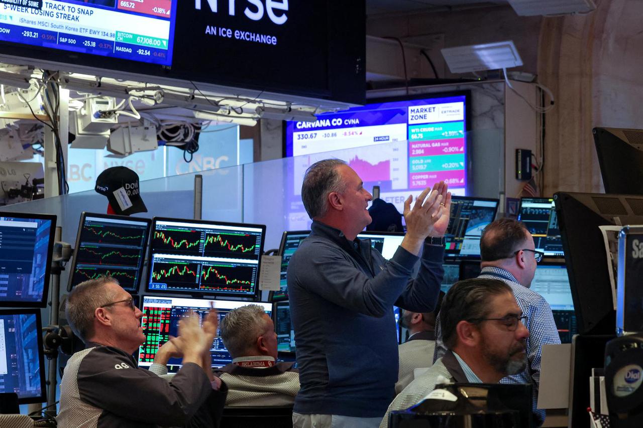 Traders react to the Olympics Women's Ice Hockey Gold Medal Game on the floor of the NYSE in New York