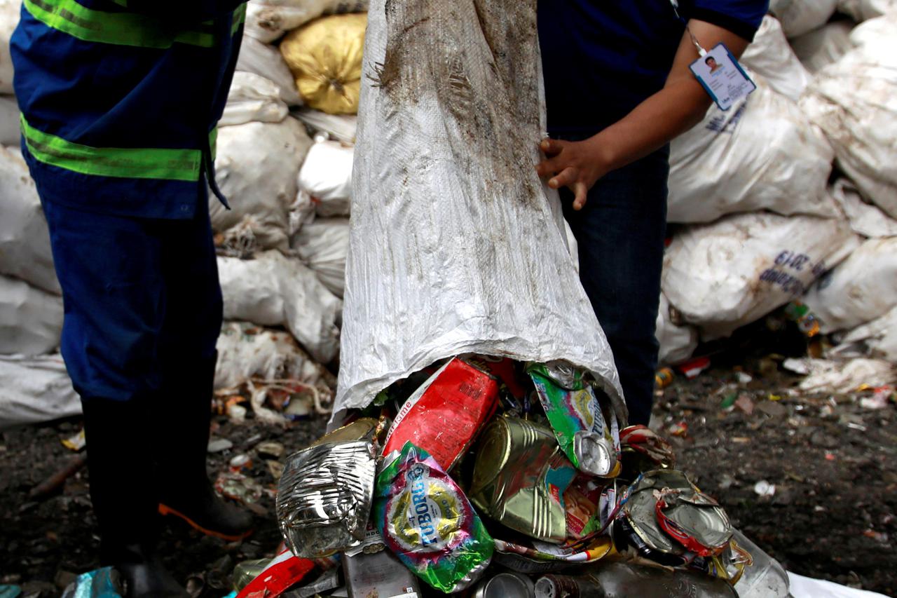 Workers from a recycling company dump garbage collected and brought from Mount Everest out of a bag, in Kathmandu