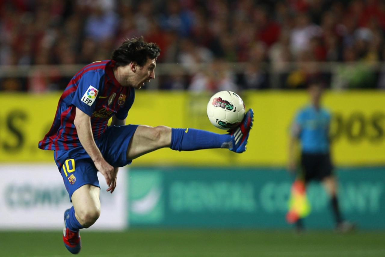 'Barcelona\'s Lionel Messi jumps as he controls the ball during their Spanish First Division soccer match against Sevilla at Ramon Sanchez Pizjuan stadium in Seville March 17, 2012. REUTERS/Marcelo de