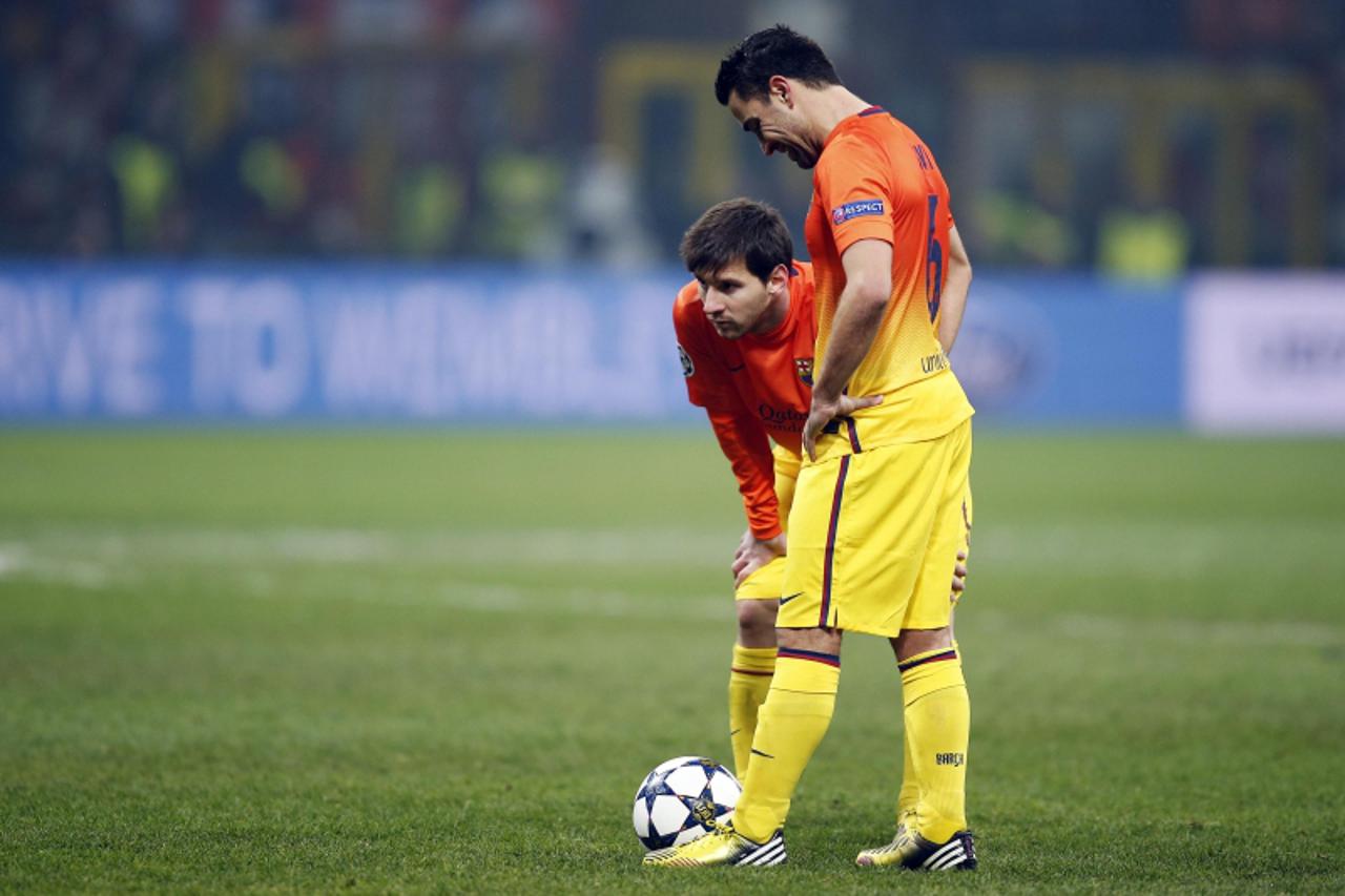 'Barcelona\'s Lionel Messi (L) and Xavi Hernandez react following AC Milan\'s second goal during their Champions League soccer match at the San Siro stadium in Milan February 20, 2013. REUTERS/Tony Ge