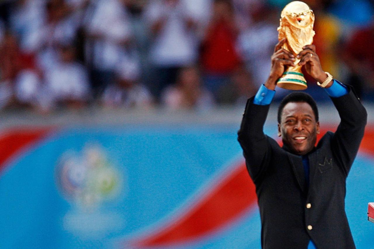 'Brazilian soccer legend and member of the 1958, 1962 and 1970 World Cup-winning Brazilian soccer teams Pele holds the World Cup trophy during the World Cup 2006 opening ceremony in Munich June 9, 200