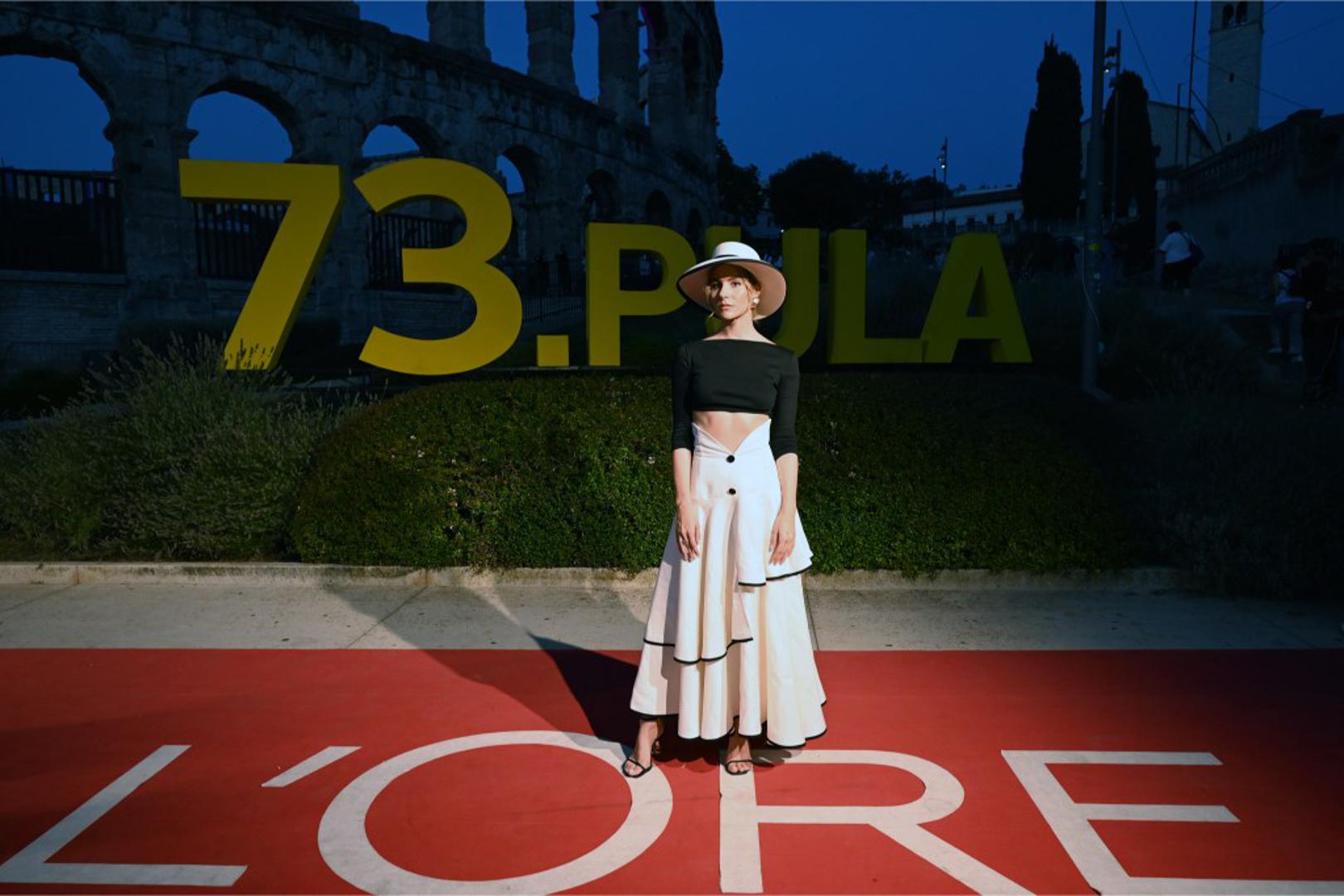 Tihana Lazović oduševila je spojem maksi suknje u boji vanilije, jednostavnog crnog topa i upečatljivog slamnatog šešira. Chic styling s mediteranskim prizvukom istaknuo se kao jedno od najoriginalnijih izdanja na crvenom tepihu.