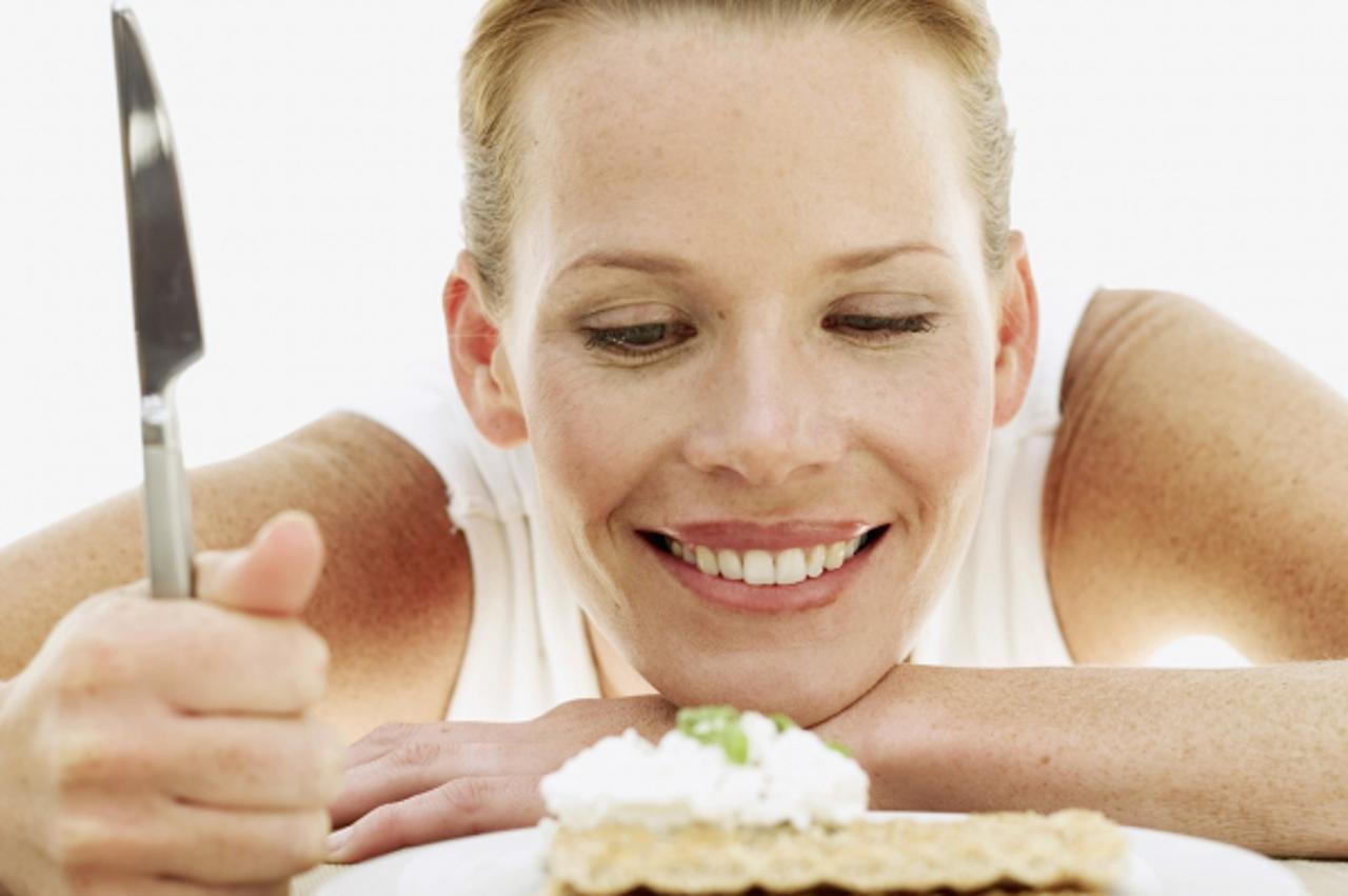 'young woman looking at a plate of sesame seed crackers with cream'
