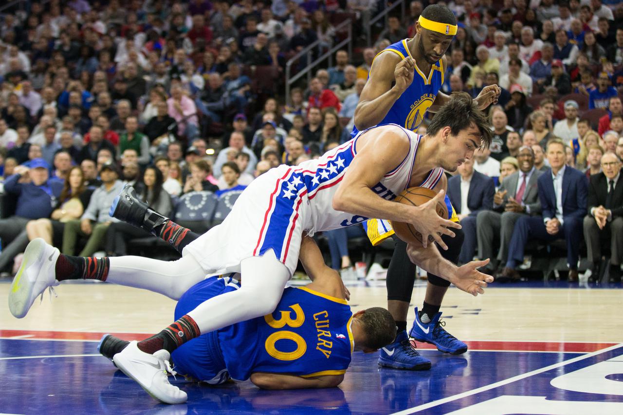 NBA: Golden State Warriors at Philadelphia 76ers Feb 27, 2017; Philadelphia, PA, USA; Philadelphia 76ers forward Dario Saric (9) controls the ball as he falls over Golden State Warriors guard Stephen Curry (30) during the second half at Wells Fargo Center