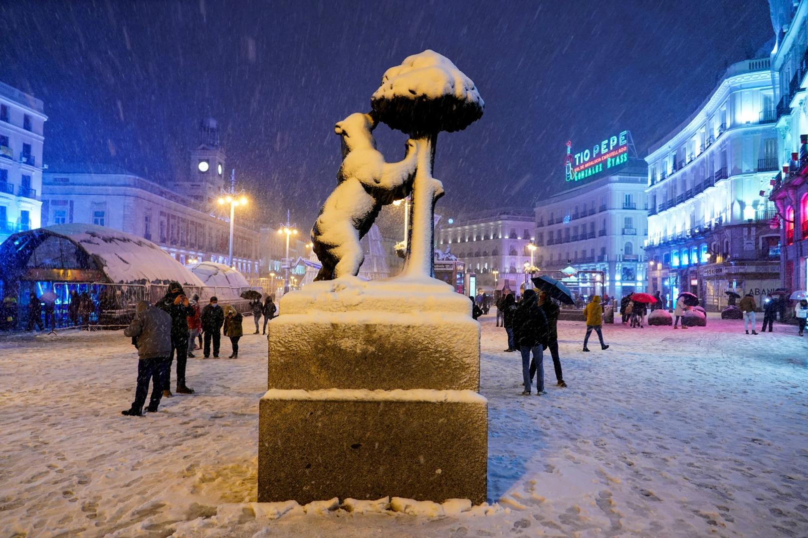 Snowfall in Madrid People walk by the snow-covered El Oso y El Madrono (The Bear and the Strawberry Tree) statue at Puerta del Sol square during snowfall in Madrid, Spain, January 8, 2021. REUTERS/Juan Medina JUAN MEDINA