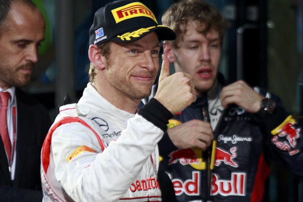 'McLaren Formula One driver Jenson Button (C) of Britain celebrates his victory after the Australian F1 Grand Prix at the Albert Park circuit in Melbourne March 18, 2012.    REUTERS/Daniel Munoz (AUST